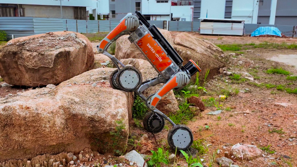 a four legged robot on wheels climbing rocks